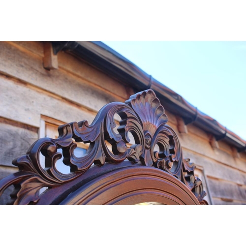 605 - A hardwood arch top cheval mirror with ornate carved finial, bevelled plate 53 3/4