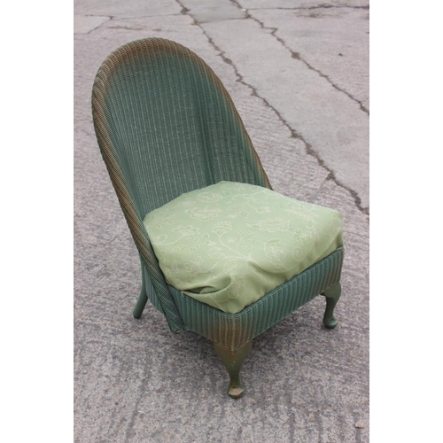 612 - A green and gold painted Lloyd Loom nursing chair with floral upholstered seat, on cabriole supports