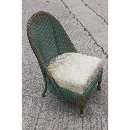 612 - A green and gold painted Lloyd Loom nursing chair with floral upholstered seat, on cabriole supports