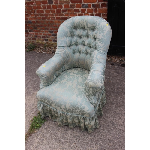 618 - A button back armchair, upholstered in a light green brocade, on ebonised and castored supports