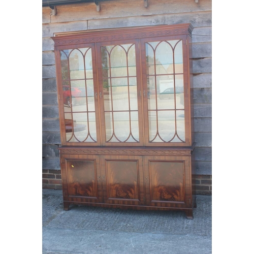 636 - * A mahogany bookcase of Georgian design enclosed three lattice glazed doors over cupboards, 60