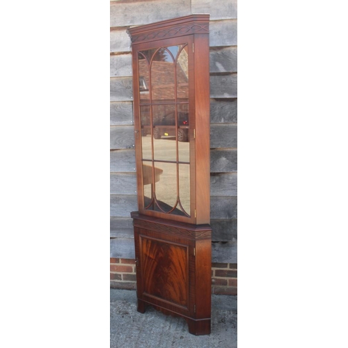 637 - * A figured mahogany corner cabinet, the upper section  enclosed lattice glazed door over one door, ... 