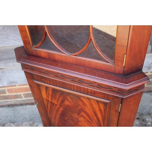 637 - * A figured mahogany corner cabinet, the upper section  enclosed lattice glazed door over one door, ... 