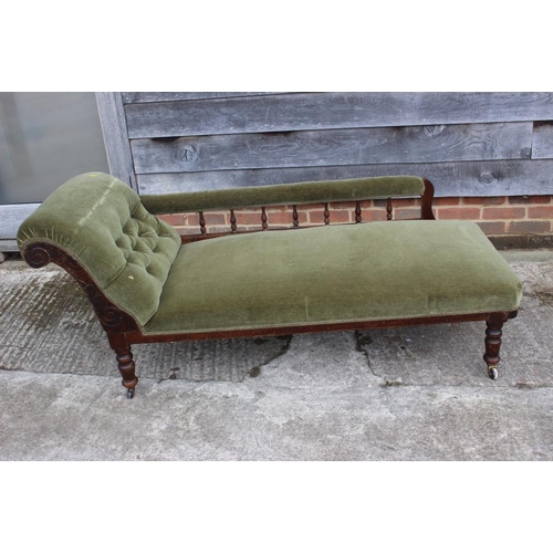 640 - An early 20th century polished as mahogany chaise longue with spindle back, upholstered in a green v... 