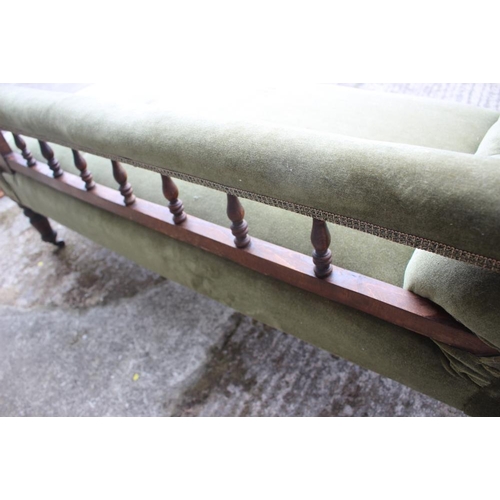 640 - An early 20th century polished as mahogany chaise longue with spindle back, upholstered in a green v... 