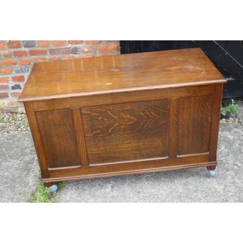 643 - An oak coffer with triple panel front, on Sheppard castors, 39