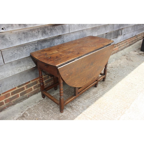 651 - An oak gate leg table with bobbin turned, squared and stretchered supports, 50