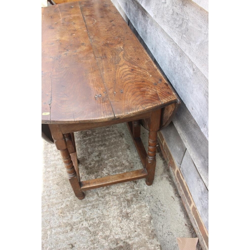 651 - An oak gate leg table with bobbin turned, squared and stretchered supports, 50