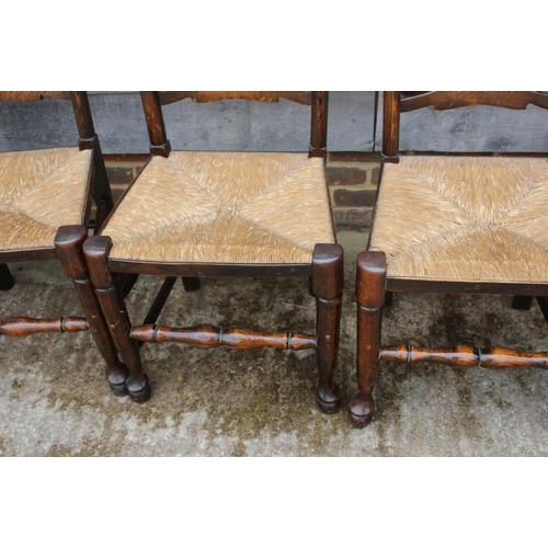 667 - A closely matched set of eight oak rush seat ladderback dining chairs, on turned and stretchered sup... 