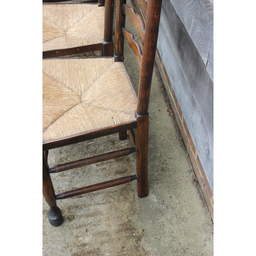 667 - A closely matched set of eight oak rush seat ladderback dining chairs, on turned and stretchered sup... 