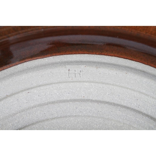 73 - S F H: a studio pottery shallow charger with incised fish rim, 16