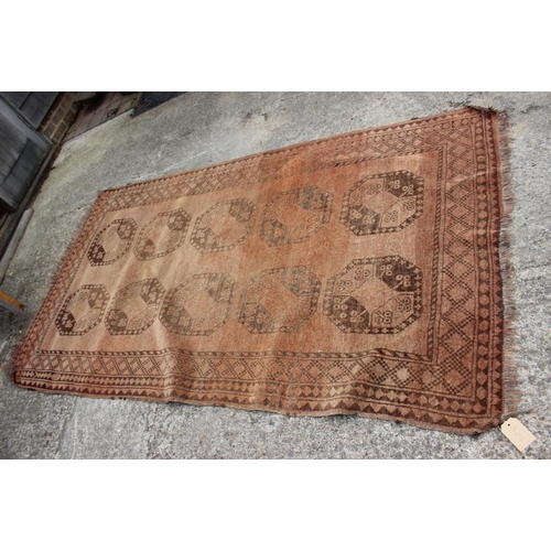 762 - A Bokhara rug with ten central medallions on a faded red ground, 50