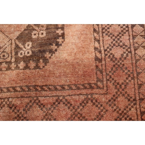 762 - A Bokhara rug with ten central medallions on a faded red ground, 50