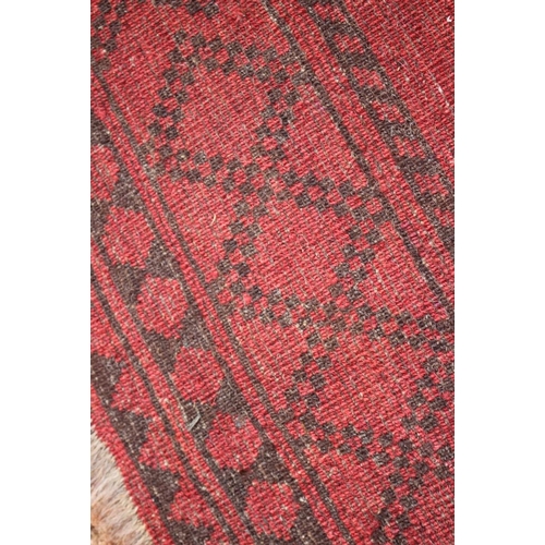 762 - A Bokhara rug with ten central medallions on a faded red ground, 50