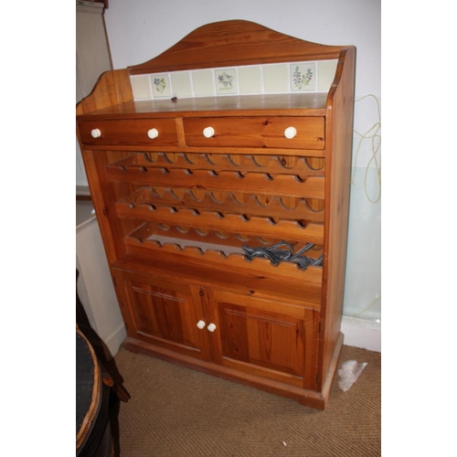 663 - A waxed pine tile back bottle rack with drawers over cupboards, 48