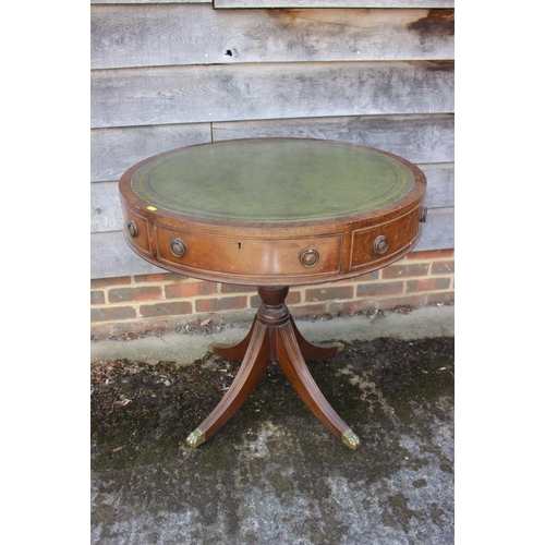 664 - A mahogany drum table with tooled lined gilt green leather top, fitted three drawers, on turned colu... 