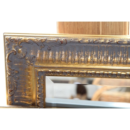 611 - A bevel edged wall mirror, in deep swept gilt frame, 23