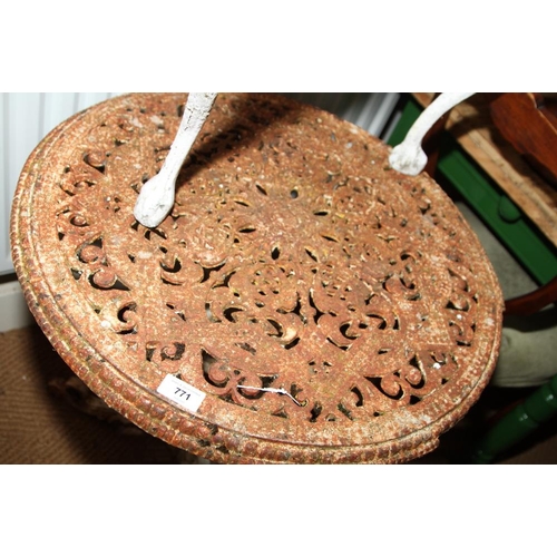 771 - A cast iron and painted circular garden table with pierced decoration and tripod supports, 24