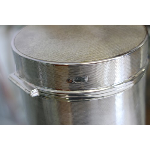 374 - An Edwardian silver cylindrical hinged box with all-over engine turned decoration and engraved armor... 