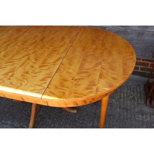 582 - * A satin birch circular extending dining table with two extra leaves, on central column and quadrup... 