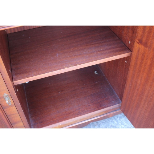 586 - * A mahogany bookcase of Georgian design enclosed three lattice glazed doors over cupboards, 60