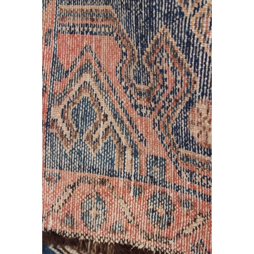 697 - A Caucasian tribal rug with one medallion on a blue ground and multi-bordered in shades of pink, 48