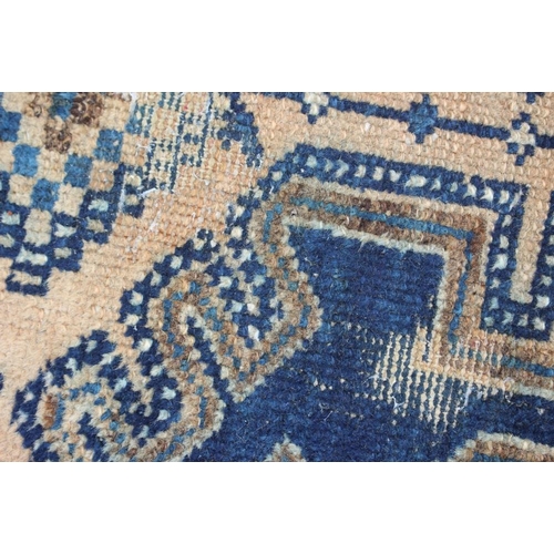 697 - A Caucasian tribal rug with one medallion on a blue ground and multi-bordered in shades of pink, 48