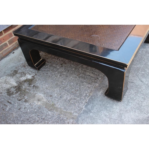 612 - An ebonised and cane effect coffee table, on square supports, 39 1/2