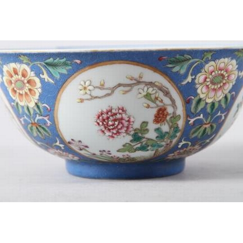 113 - A Chinese famille rose bowl, decorated panels with various flowers on a blue textured glazed ground,... 