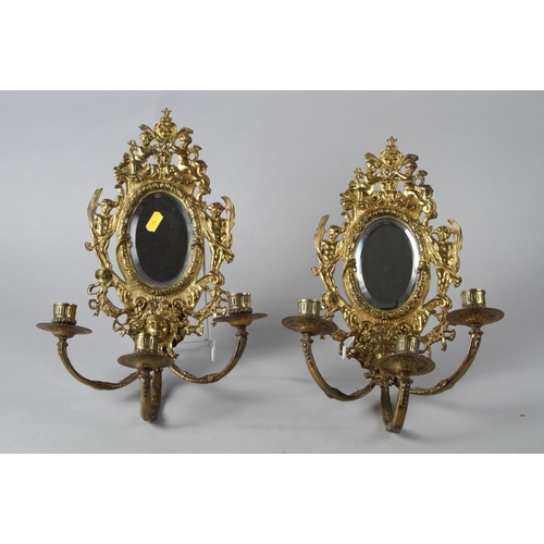 250 - A pair of brass three-light girandoles with oval mirror plates, 15