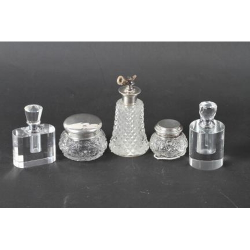 299 - Two silver topped dressing table jars, two white metal topped scent bottles and a similar atomizer, ... 