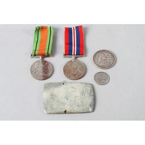 357 - A WWII Defence Medal, another medal, an 1880 silver dollar and other items