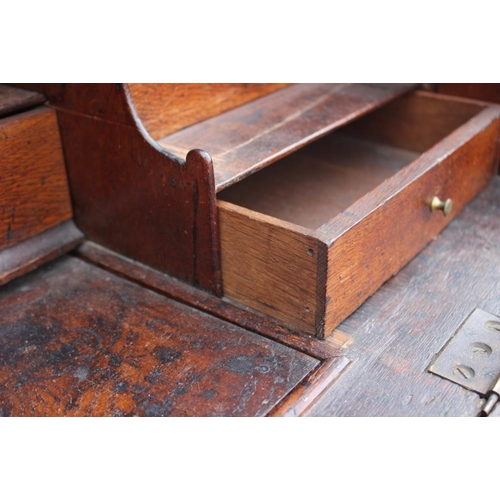 534 - An early 19th century Continental oak bombe-shape fall front bureau, the upper section fitted drawer... 