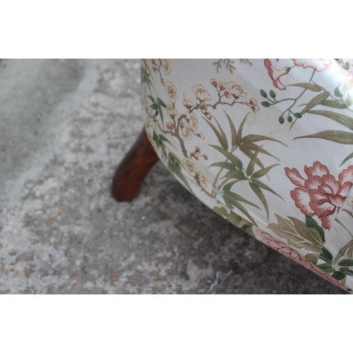 535 - A late 19th century low seat nursing chair, upholstered in a chinoiserie glazed chintz, on turned an... 