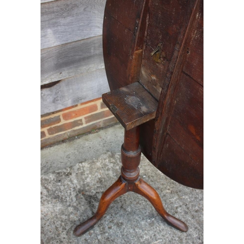 539 - A Georgian provincial oak circular tilt top occasional table, on vase turned column and tripod splay... 