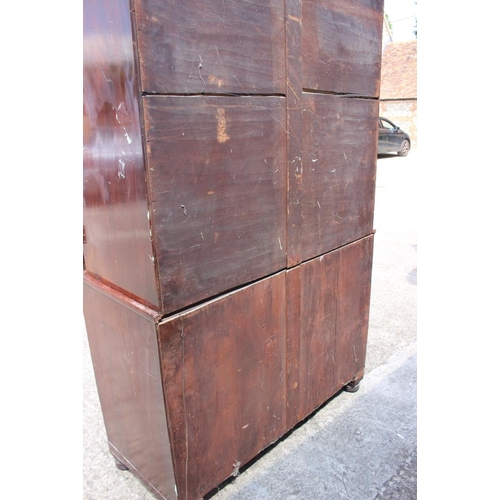 541 - A 19th century figured mahogany linen press, the upper section fitted pull-out trays enclosed two pa... 