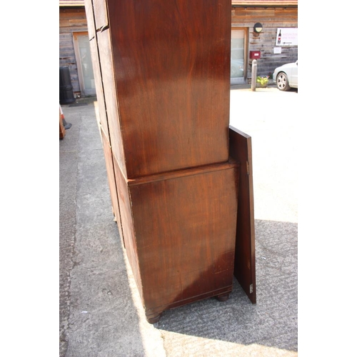 541 - A 19th century figured mahogany linen press, the upper section fitted pull-out trays enclosed two pa... 