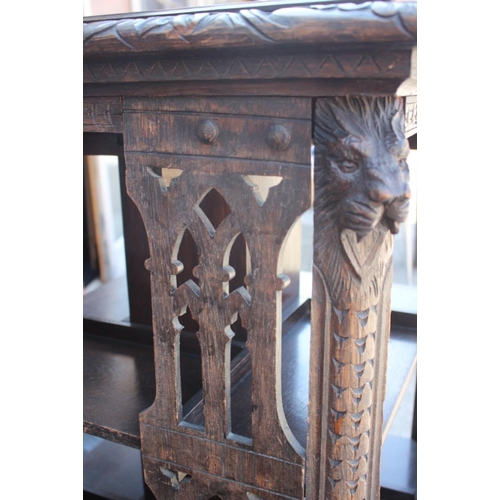 550 - A late Victorian carved oak three-tier revolving bookcase with Gothic pierced sides, 25