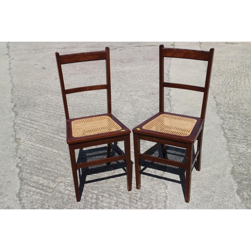 593 - A pair of Edwardian carved mahogany bedroom chairs with cane seat panels, on stretchered supports