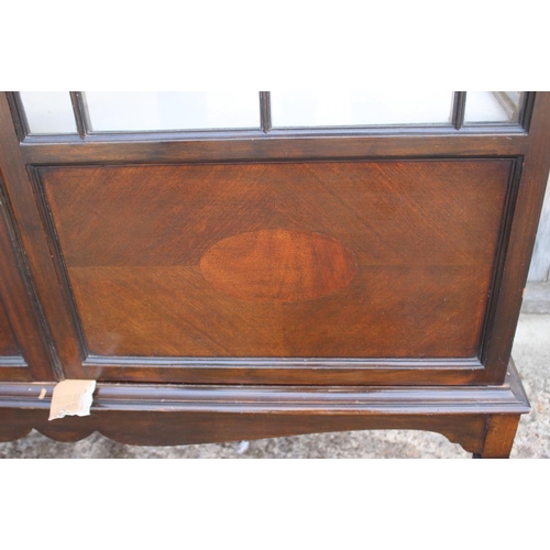 600 - A mahogany display cabinet enclosed two lattice glazed doors, on square taper supports, 42