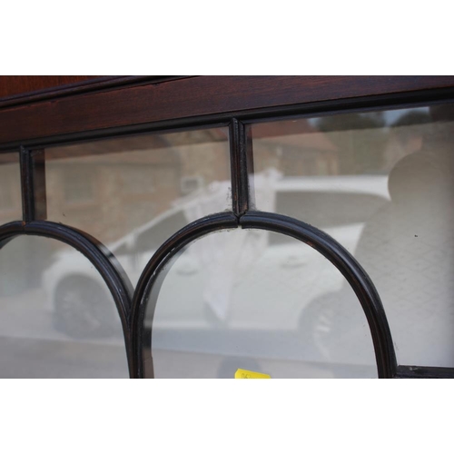 600 - A mahogany display cabinet enclosed two lattice glazed doors, on square taper supports, 42