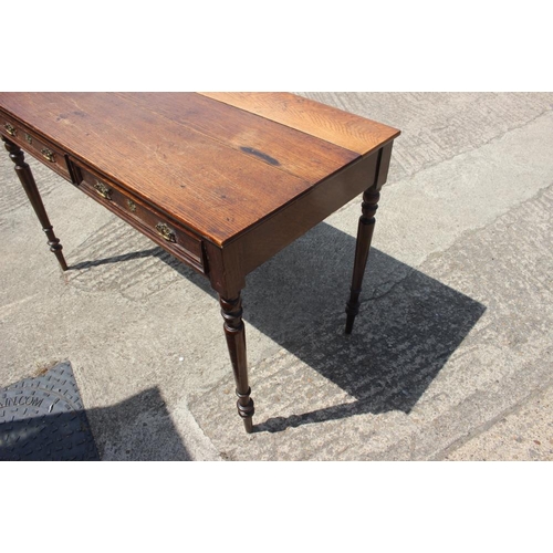 601 - An oak side table, fitted two drawers, on turned and tapering supports, 46