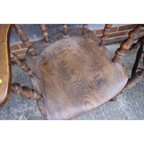 628 - A pair of captain's spindle back elbow chairs with panel seats, on turned and stretchered supports