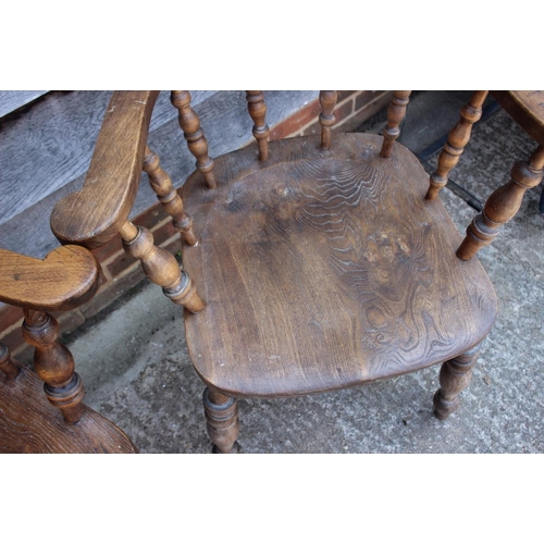 628 - A pair of captain's spindle back elbow chairs with panel seats, on turned and stretchered supports