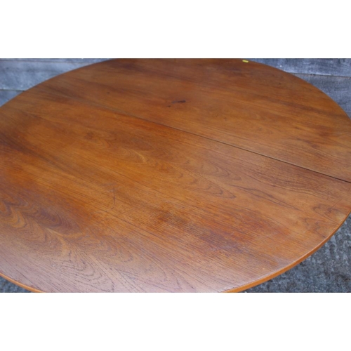 629 - A 1960s teak circular extending dining table with one extra leaf, 48