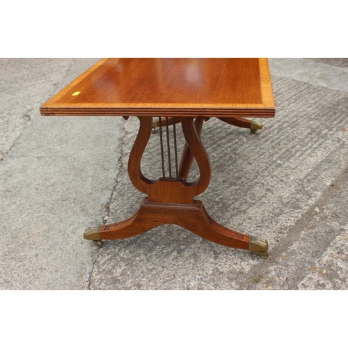 670 - A mahogany and banded coffee table, on lyre end supports, 42