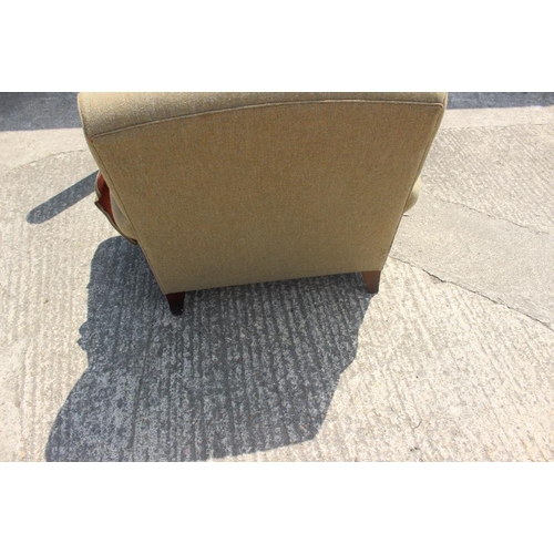 677 - A deep seat armchair, upholstered in a khaki wool fabric, on square taper supports