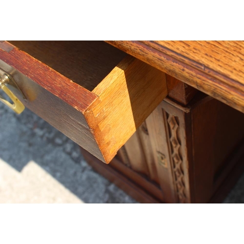 680 - An early 20th century oak desk of Gothic design, fitted two drawers and central recess over cupboard... 