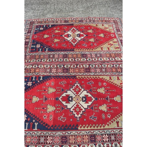 700 - A pair of Konya tribal rugs with lamp design on a red ground and multi-star borders in shades of red... 