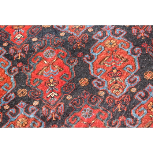 706 - A Hamadan type rug with all-over gul design on a blue ground and broad floral border, 66